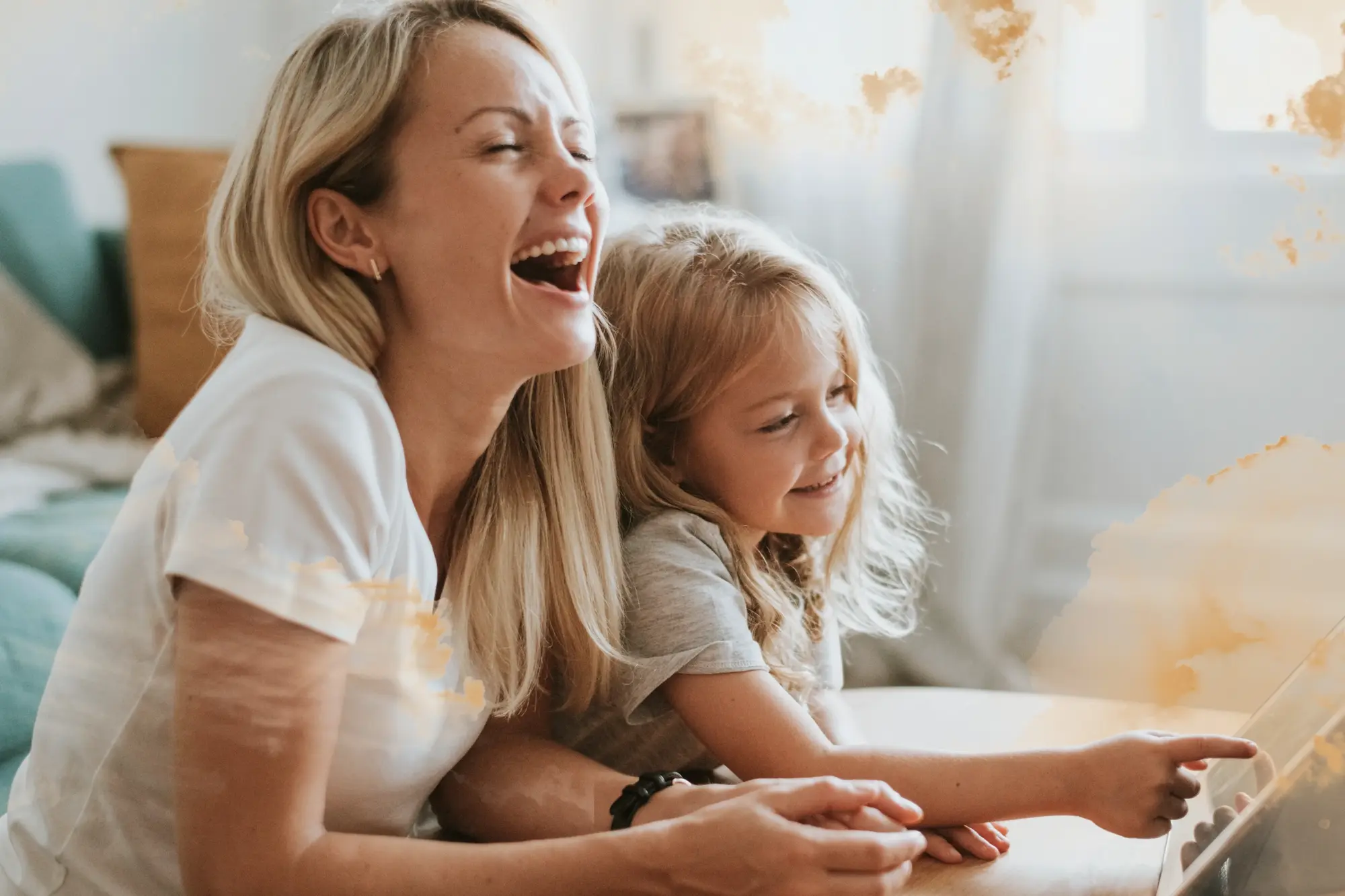 A mother and daughter laughing together on a couch
